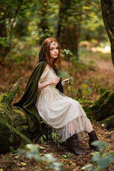 モスツリーの近くの緑の中世のドレスで美しい赤毛の女の子の肖像画 エルヴェンについてのおとぎ話話 森でポーズするAmazingモデル 暖かい芸術作品 — ストック写真