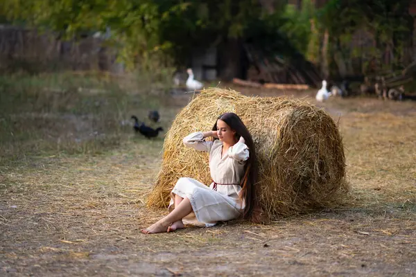 穿着乌克兰传统服饰的漂亮的超长辫子女在农场里摆姿势 色彩艳丽 背景温暖的年轻貌美女子的画像 — 图库照片