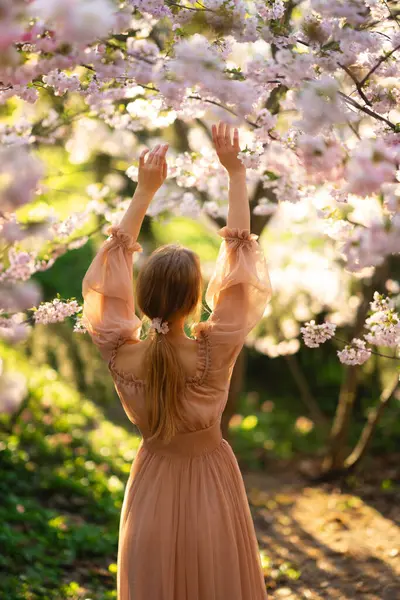 漂亮的女孩穿着粉红色的老式衣服站在五彩缤纷的花朵旁边 浪漫女人的艺术作品 花圃中的美丽柔情模型 免版税图库图片