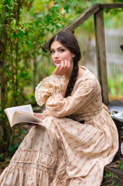 Oldukça uzun saçlı, esmer, esmer, eskimiş dantel elbiseli bir kız. Şefkatli romantik model.