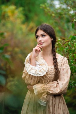 Oldukça uzun saçlı, esmer, esmer, eskimiş dantel elbiseli bir kız. Şefkatli romantik model.