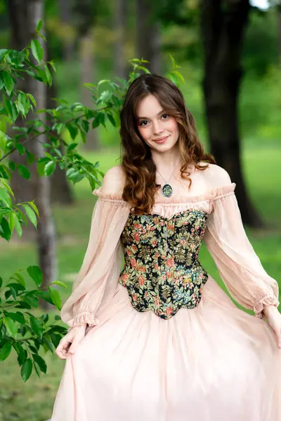 Çiçekli leylak bahçesinde poz veren klasik korse giymiş romantik bir kadın.