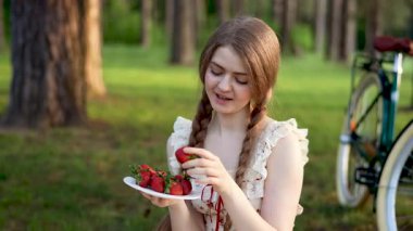 Yaz Ormanı Kırsal Piknik Sahnesinde Çilek ve Bisiklet Tutan Genç Kadın 'ın Videosu