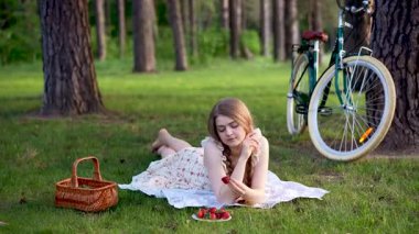 Yaz Ormanı Kırsal Piknik Sahnesinde Çilek ve Bisiklet Tutan Genç Kadın 'ın Videosu