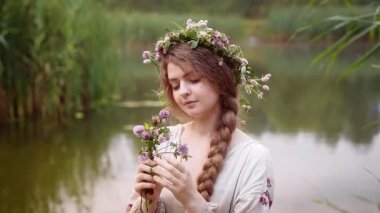 Ukrayna 'nın geleneksel etnik kıyafetleri içinde iki genç kadın fotoğraf çekimi sırasında nehirde duruyor.