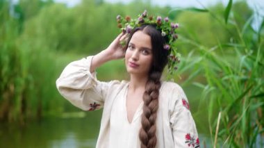 Ukrayna 'nın geleneksel etnik kıyafetleri içinde iki genç kadın fotoğraf çekimi sırasında nehirde duruyor.