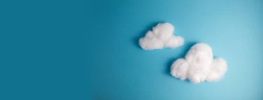 Pattern of white fluffy clouds made of cotton wool on a blue background. High quality photo