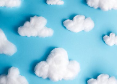 Pattern of white fluffy clouds made of cotton wool on a blue background. High quality photo