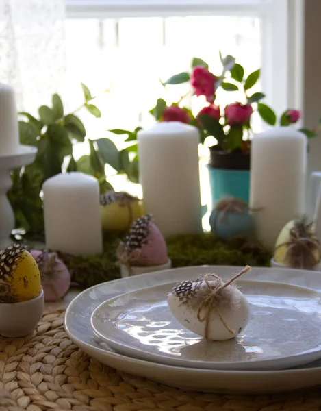 Festive table setting and spring decor with candles, easter eggs and flowers. High quality photo