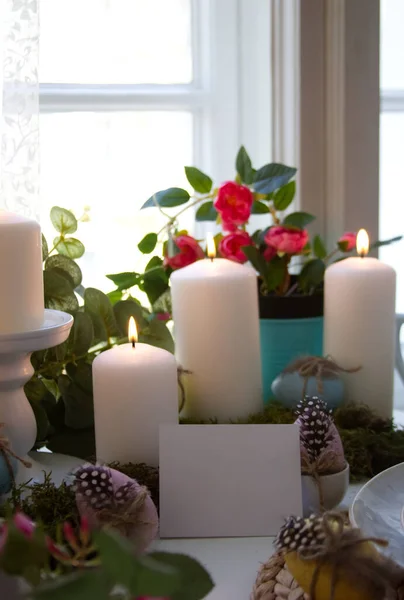 White candles and festive easter eggs and white card copy space. High quality photo