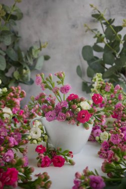 White cup with spring flowers instead of coffee on the table close-up. High quality photo