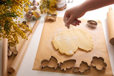Kadın elleri bahar dekorunda hamuru masanın üzerine serpiştirir. Yüksek kalite fotoğraf