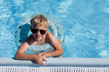 Havuzda yüzen sarı saçlı çocuk fotokopi odasında.