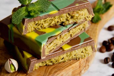 Dubai çikolatasını yeşil kadaif ve ahşap tezgahta fıstık ezmesi ile kapatın.