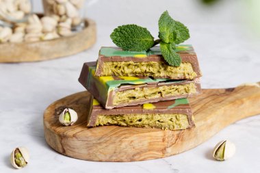 Dubai çikolatası, yeşil kadaif ve ahşap tezgahta fıstık ezmesi