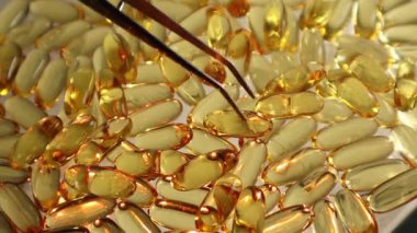 Cımbız gibi üst görünüm Omega 3 balık yağı kapsüllerini ayırır