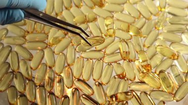 Cımbız gibi üst görünüm Omega 3 balık yağı kapsüllerini ayırır