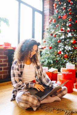 Genç bir kadın Noel ağacının orada video görüşmesi yapıyor. Noel çevrimiçi tatil. 