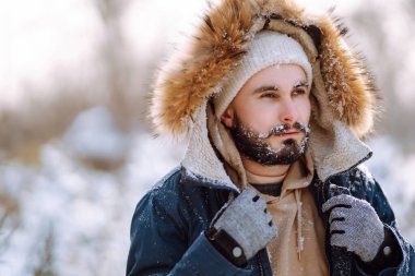 Kış parkında kameraya gülümseyen sakallı adam. Sezon, Noel, seyahat ve insanlar konsepti.