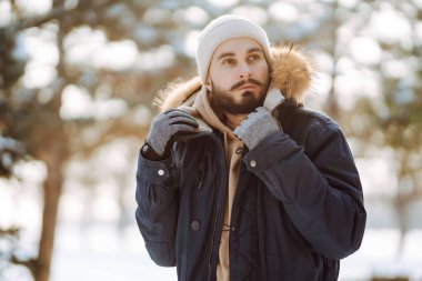 Kış parkında kameraya gülümseyen sakallı adam. Sezon, Noel, seyahat ve insanlar konsepti.