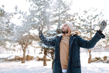Kış parkında kameraya gülümseyen sakallı adam. Sezon, Noel, seyahat ve insanlar konsepti.