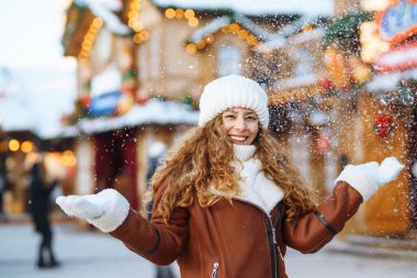 Noel pazarında süslü büfeler ve büfeler arasında yürüyen güzel bir kadın. Tatiller, dinlenme, seyahat konsepti.