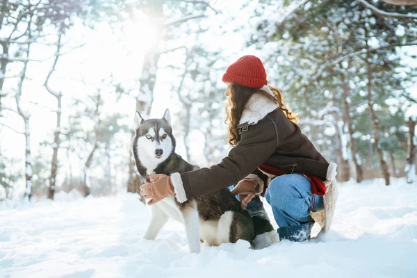 年轻女子在冬天遛狗 两人带着嬉闹的心情一起探索雪地 宠物和人类 — 图库照片