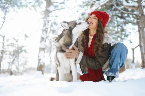 冬に犬を散歩する若い女性と雪を一緒に遊び心のある気分で探索します ペット — ストック写真