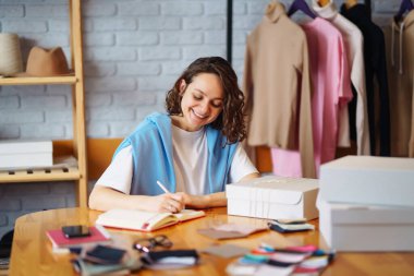 Küçük işletme sahibi, girişimci, ecommerce giyim mağazası siparişlerini kontrol eden bir satıcı. Çevrimiçi satış.