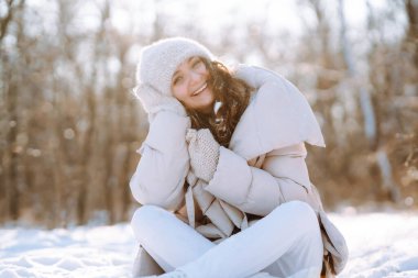 Kış gülen kadın kış ormanlarında karlı ağaçların arasında duruyor..