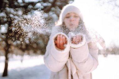 Kış gülen kadın kış ormanlarında karlı ağaçların arasında duruyor..