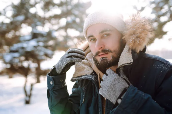 stock image Young man in snowy winter forest. Season, christmas, travel and people concept.