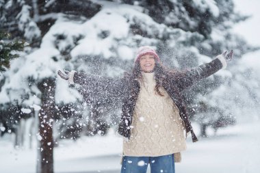 Ormandaki ilk karın tadını çıkaran mutlu kadın. Tatiller, dinlenme, seyahat konsepti