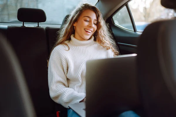 坐在车上 坐在笔记本电脑上工作的美丽而自信的女人 业务概念 — 图库照片