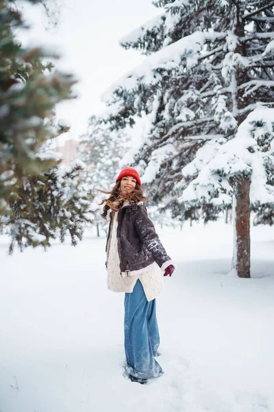 Happy woman  enjoying first snow in the forest. Holidays, rest, travel concept