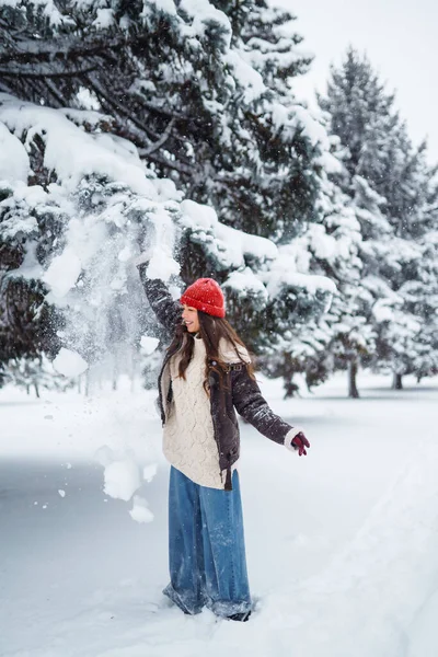 Happy woman  enjoying first snow in the forest. Holidays, rest, travel concept