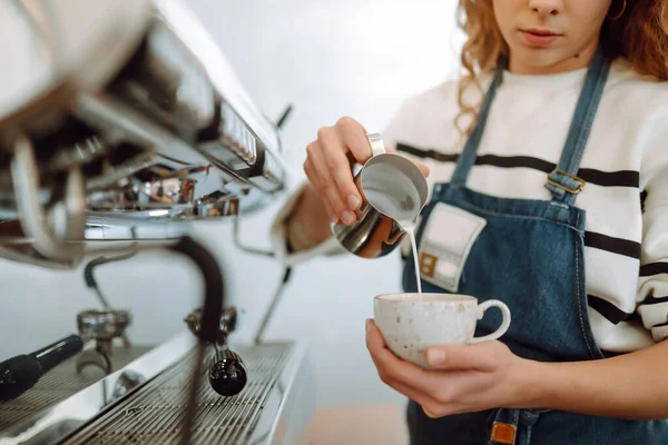 Barista elinde kahve bardağıyla kahve makinesinin hazırladığı taze kahveyi getiriyor. Profesyonel kahve demleme..