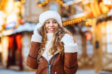 Gülümseyen kadın sokak pazarında poz veriyor. Noel festivali, kış tatili konsepti..