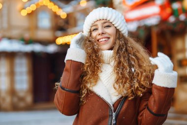 Gülümseyen kadın sokak pazarında poz veriyor. Noel festivali, kış tatili konsepti..