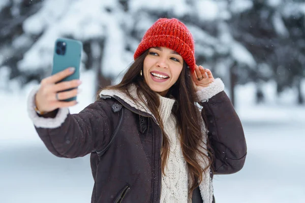 stock image Young woman taking selfie in winter forest. Holidays, rest, travel concept.