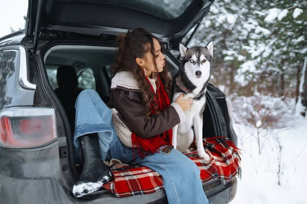 年轻的女人和可爱的哈士奇狗在雪地里尽情享受寒假 旅行概念 — 图库照片