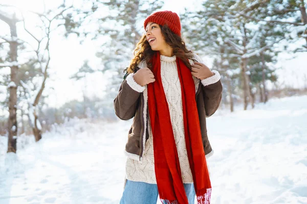 美丽的年轻微笑的女人穿着冬暖夏凉的衣服在雪地里散步 — 图库照片