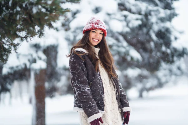 年轻的女人笑着在一个冬季的雪地公园里打雪 旅行概念 — 图库照片