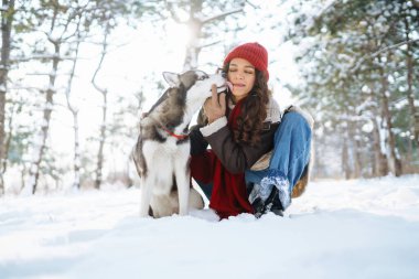 Kışın köpeğini gezdiren mutlu bir kadın ve her ikisi de neşeli bir ruh hali içinde karı keşfeder. Dostluk, evcil hayvan ve insan.