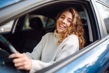 Arabadan sana gülümseyen güzel kadın sürücü. Otomobil yolculuğu, seyahat, yaşam tarzı konsepti. Araba paylaşımı.
