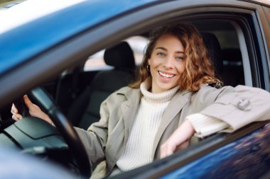 Arabadan sana gülümseyen güzel kadın sürücü. Otomobil yolculuğu, seyahat, yaşam tarzı konsepti. Araba paylaşımı.