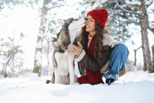 冬に犬を散歩する幸せな女性と 雪を一緒に遊び心のある気分で探索してください ペット — ストック写真