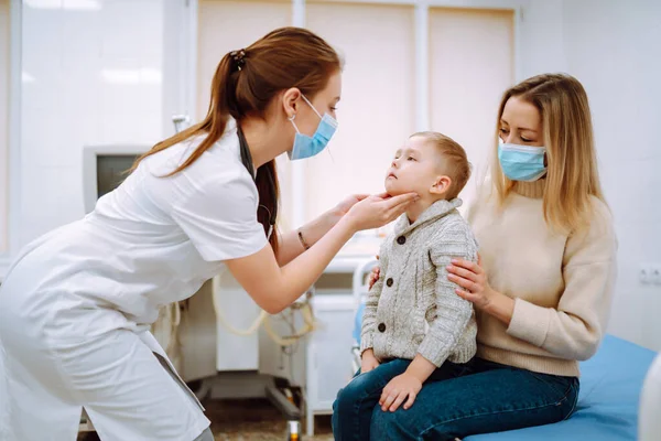 小児科医はその病気の少年を調べる 小児科医又は耳鼻咽喉科医の職にある母親との間の子 — ストック写真