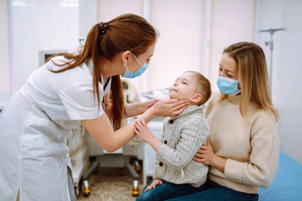 小児科医はその病気の少年を調べる 小児科医又は耳鼻咽喉科医の職にある母親との間の子 — ストック写真