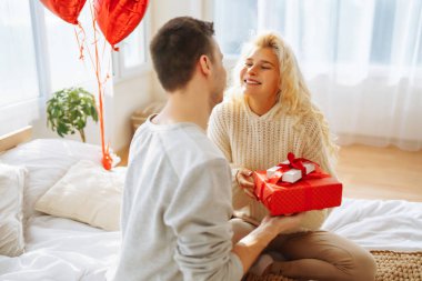 Hediye değişimi. Evde Sevgililer Günü 'nü kutlayan genç bir çift. Birlikte romantik bir gün..